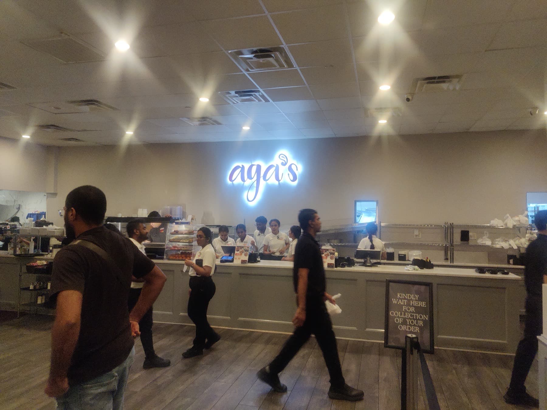 Takeout counter at Aga’s in Houston with packed bags and a wait-here-for-collection sign
