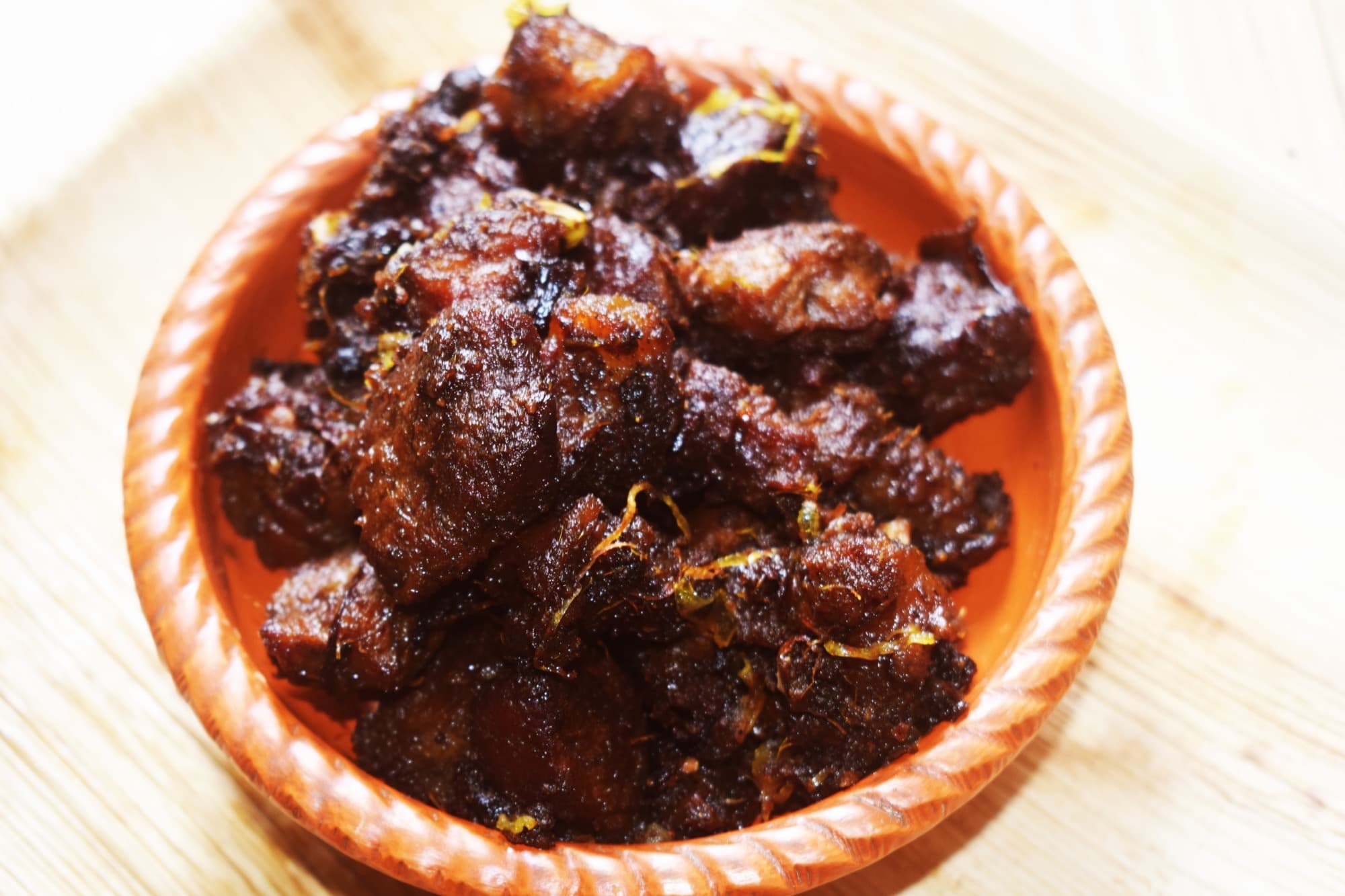 Kala bhuna in a terracotta bowl: dark, reduced meat with a concentrated spice coating