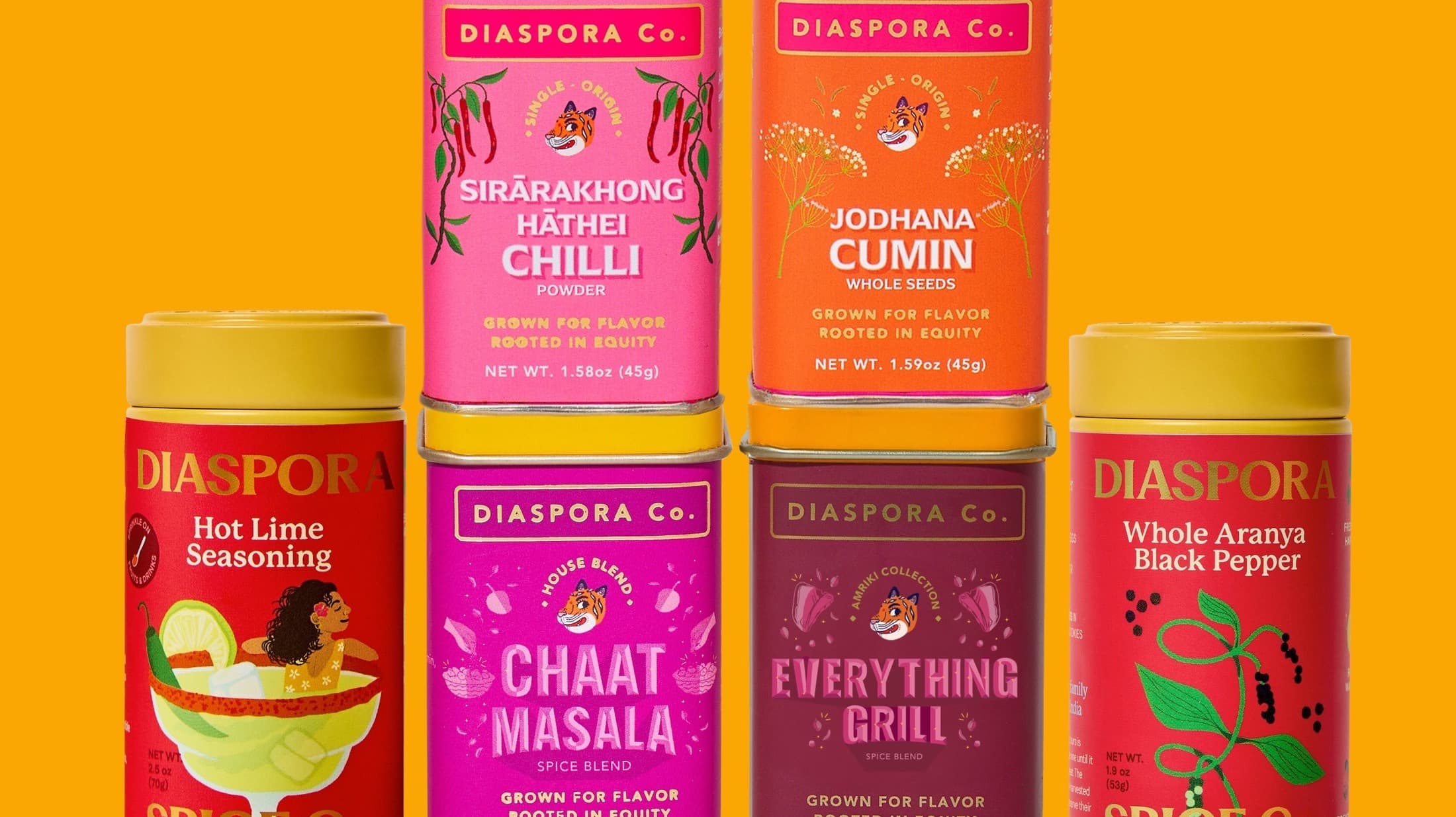 Diaspora Co. spice tins including chilli, cumin, chaat masala, and black pepper on a yellow backdrop