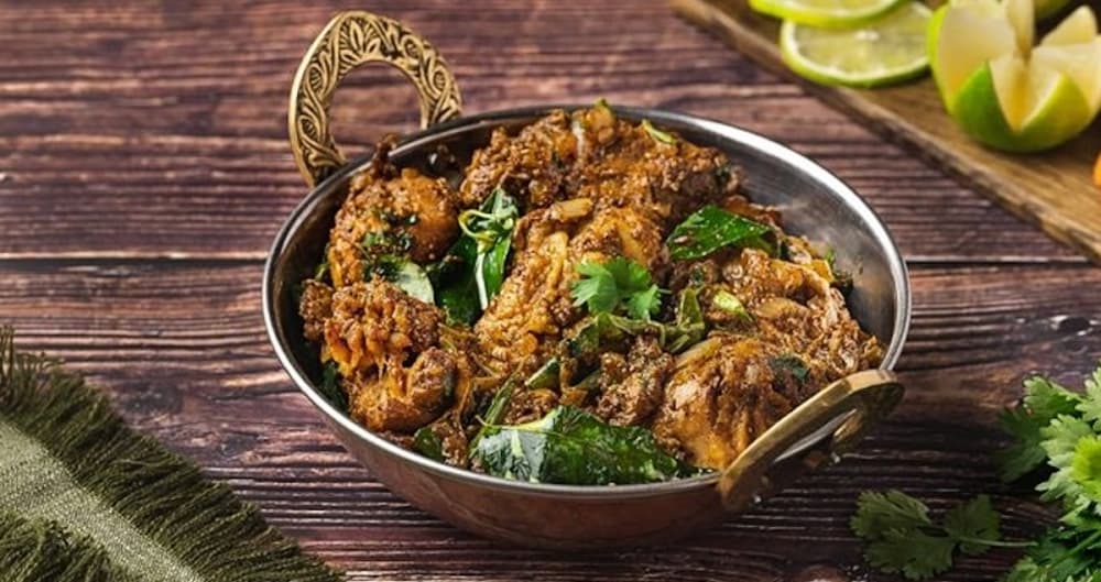 Assorted Sangam Chettinad masala and curry plates on a wooden table