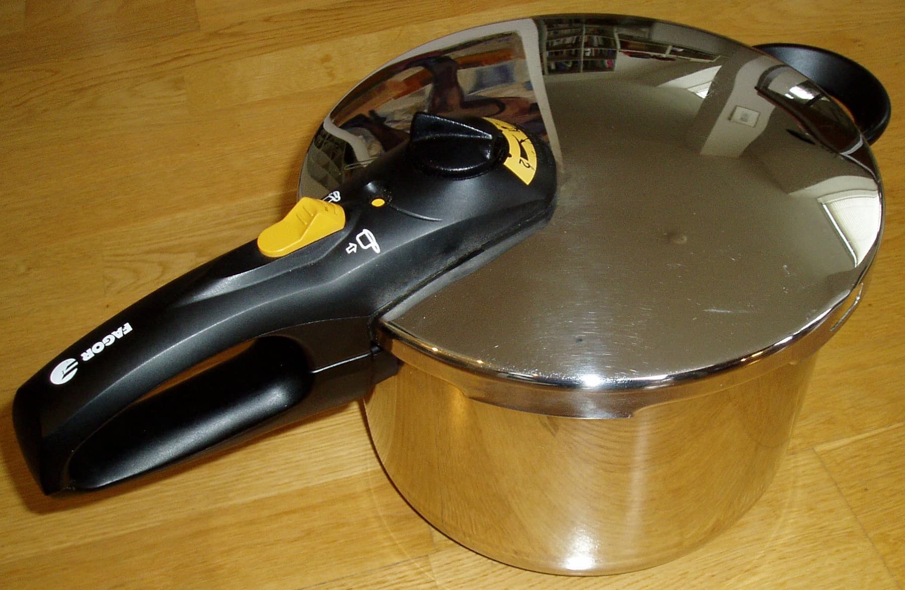 Stovetop pressure cooker with regulator whistle on the lid