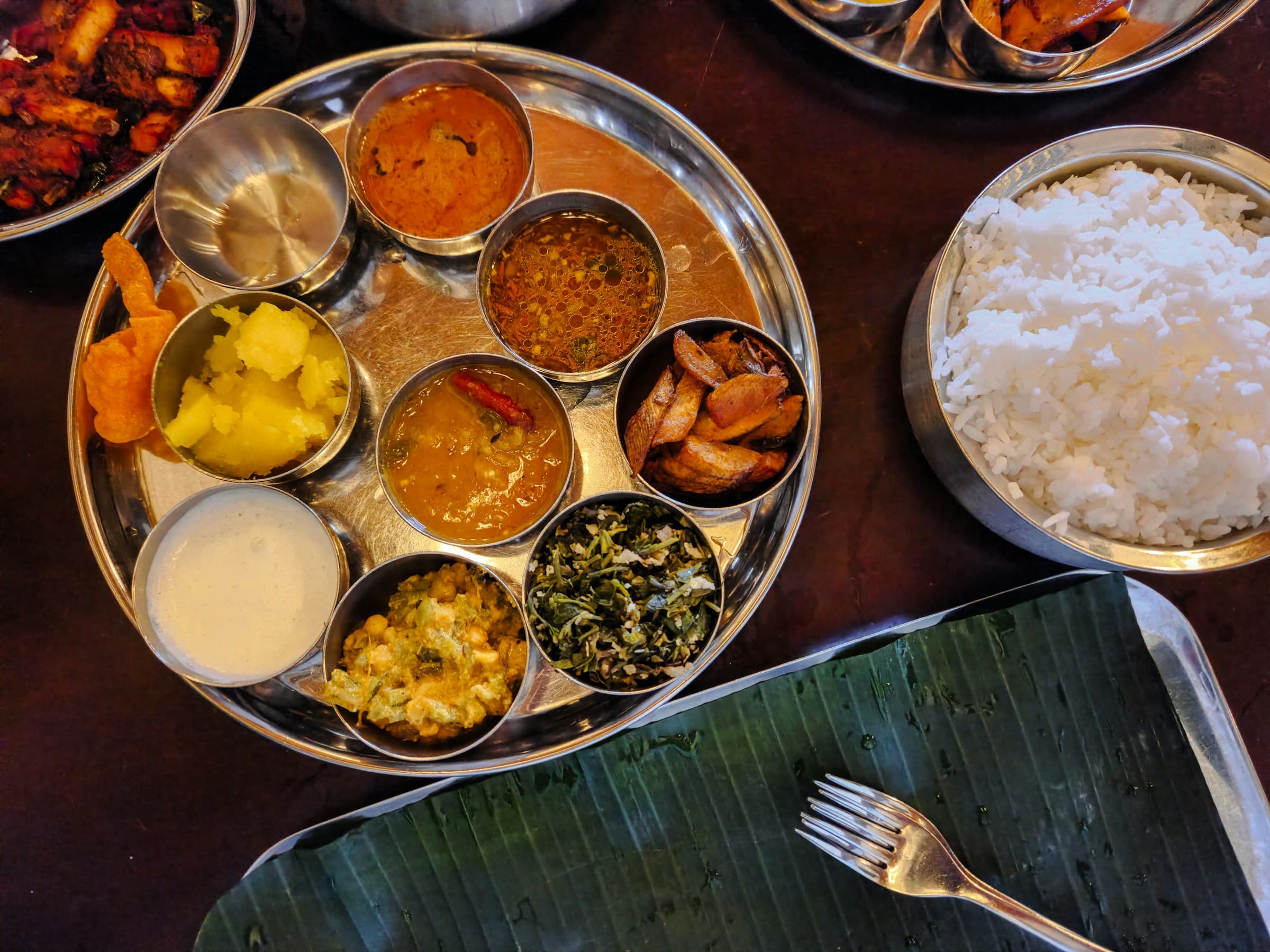 Tamil vegetarian lunch thali with rice, gravies, vegetables, curd, and a banana leaf